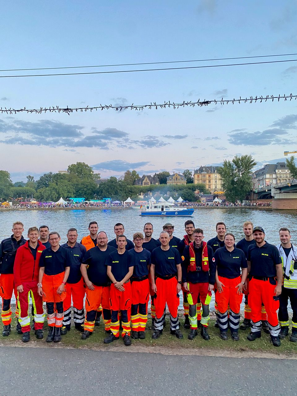 Gruppenfoto von DLRG-Einsatzkräften an einem Flussufer.